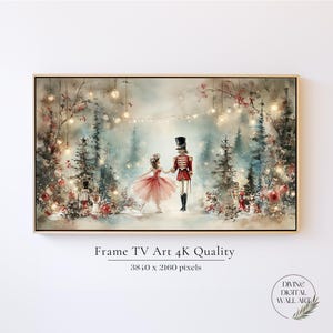 May include: A digital wall art print for a frame TV featuring a watercolor-style scene of a ballerina in a pink tutu and a nutcracker in a red uniform dancing in a snowy forest with glowing string lights, red ornaments, and pine trees.