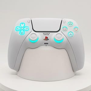 May include: A white wireless video game controller featuring a central PlayStation logo, dual analog sticks with glowing cyan rings, a directional pad with cyan illumination, and four action buttons with cyan accents.