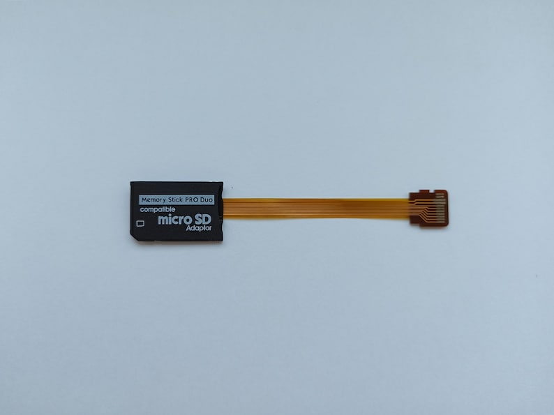 May include: Black Memory Stick PRO Duo compatible micro SD adaptor with a gold coloured ribbon cable.