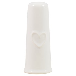 May include: White ceramic bottle stopper with a heart design.