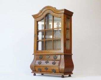 Petite charmante armoire en bois de chêne avec une porte en verre et des tiroirs, affichage vintage de style baroque, stockage d'apothicaire de médecine en verre