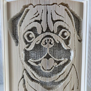 May include: A book sculpture of a pug dog's face, created by folding the pages of a book. The sculpture is made of white paper and has a 3D effect.