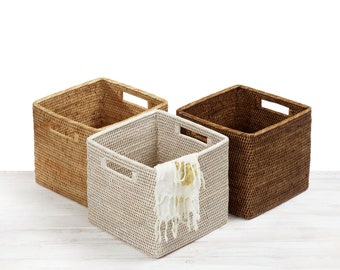 May include: Three woven storage baskets, one white, one brown, and one natural, with a white cloth in the white basket.