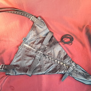 Heavy leather arm restraint in black bovine leather with shoulder straps.