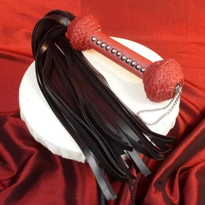 Black Rubber Stingy Flogger with Silver & Red or blue handle detail.