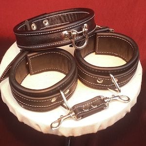 Neck Collar and Arm Cuff Set in Black Leather with white detail.