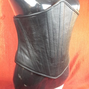 Male Corset in heavy black leather with solid front boning and rear lace up detail, fully boned and leather lined.