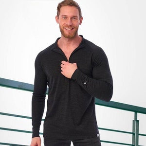 May include: A black long-sleeved shirt with a zippered collar. The shirt is made of a soft, comfortable material.
