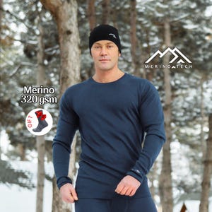 May include: A navy blue long-sleeve thermal shirt and a black beanie. The shirt features a small white logo on the cuff. Text on the image reads Merino 320 gsm and GIFT with an illustration of a sock featuring a red bow.