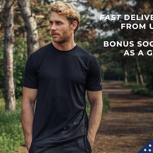 May include: A man wearing a black t-shirt stands in a forest. The text "FAST DELIVERY FROM USA" and "BONUS SOCKS AS A GIFT" is visible in the image.