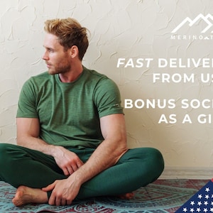 May include: A short-sleeved green t-shirt and dark green pants. The image includes the text MERINO TECH, FAST DELIVERY FROM USA, and BONUS SOCKS AS A GIFT, along with a graphic of the American flag in the bottom right corner of the frame.