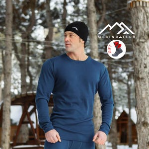May include: A long-sleeve blue crew neck shirt and a black beanie with a white logo. A circular graphic in the upper right corner displays the text MERINOTECH and an illustration of a gray sock with a red bow, labeled with the word GIFT.