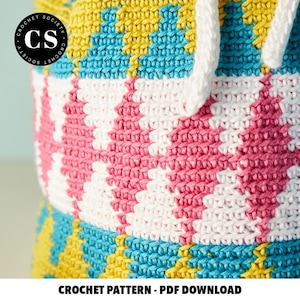 Pu&ograve; includere: Una borsa all'uncinetto con un motivo geometrico colorato in giallo, blu, rosa e bianco. La borsa ha una chiusura con coulisse ed &egrave; realizzata con un punto testurizzato. L'immagine include il testo "CROCHET PATTERN - PDF DOWNLOAD".