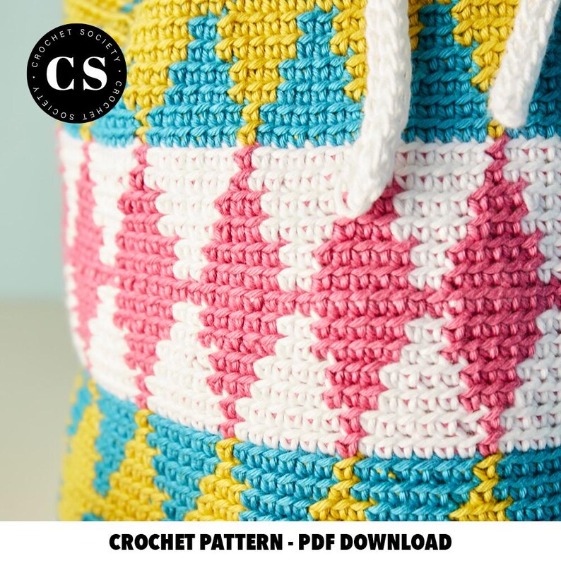 Pu&ograve; includere: Una borsa all'uncinetto con un motivo geometrico colorato in giallo, blu, rosa e bianco. La borsa ha una chiusura con coulisse ed &egrave; realizzata con un punto testurizzato. L'immagine include il testo "CROCHET PATTERN - PDF DOWNLOAD".