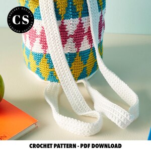 Pu&ograve; includere: Uno schema a uncinetto per uno zaino geometrico colorato con spalline bianche. Lo schema &egrave; disponibile per il download in PDF. Crochet Society.