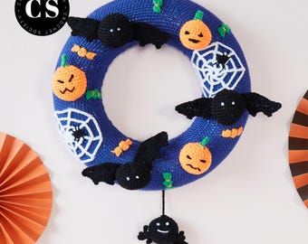 Könnte beinhalten: Ein blauer Halloween-Häkelkranz mit orangefarbenen Kürbissen, schwarzen Fledermäusen und weißen Spinnennetzen. Unten hängt eine kleine schwarze Spinne. Der Text "CROCHET PATTERN - PDF DOWNLOAD" steht unten.