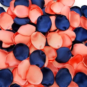 May include: A pile of peach and navy blue silk flower petals. The petals are scattered on a white background.