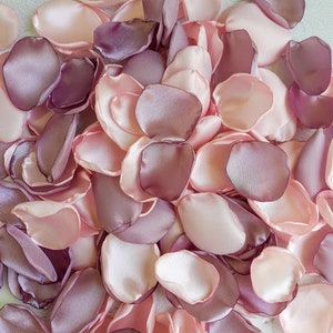 May include: A pile of pink and mauve silk rose petals. The petals are soft and delicate, perfect for weddings or other special occasions.