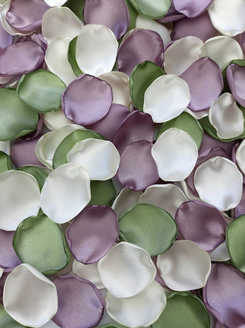 Pu&ograve; includere: Una collezione di petali di fiori di seta in tonalit&agrave; di verde, viola e bianco. I petali sono disposti in modo casuale, creando una bella ed elegante esposizione.