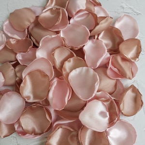 May include: A pile of blush pink satin rose petals. The petals are soft and delicate, perfect for wedding decorations or special events.