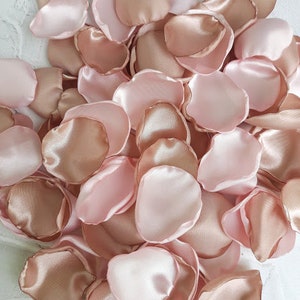 May include: A pile of rose petals in shades of blush pink and champagne. The petals are made of satin fabric and are perfect for weddings, special events, or home decor.