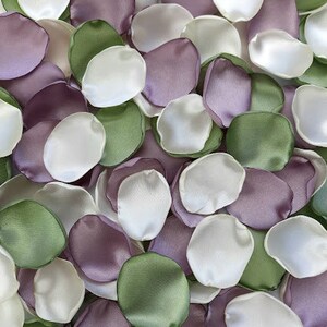 Pu&ograve; includere: Una collezione di petali di fiori di seta in tonalit&agrave; di verde, viola e bianco. I petali sono disposti in modo casuale, creando una bella ed elegante esposizione.
