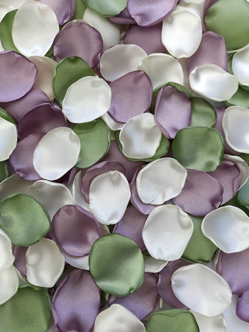 Pu&ograve; includere: Una collezione di petali di fiori di seta in tonalit&agrave; di verde, viola e bianco. I petali sono disposti in modo casuale, creando una bella ed elegante esposizione.