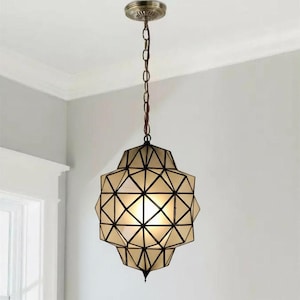 Handmade geometric pendant lamp hanging from the ceiling in a modern interior.