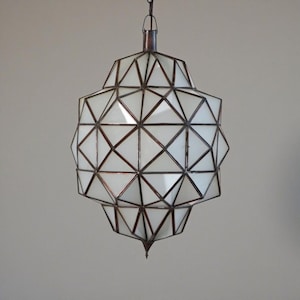 Geometric pendant lamp with white panels and dark metal framework.
