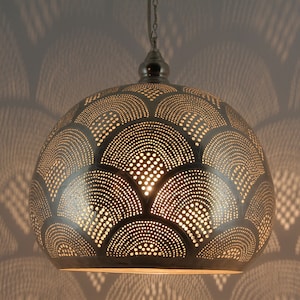 May include: A dome-shaped metal pendant light fixture with a silver finish, featuring a repeating pattern of perforated semi-circles and dots that allow light to pass through, suspended from a matching silver-toned chain and ceiling canopy.