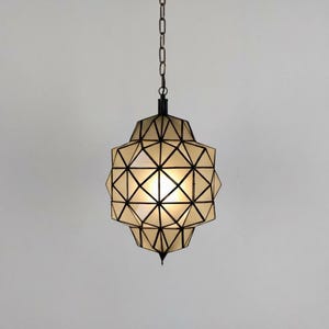 Handmade geometric hanging light with a spherical shape and detailed metal pattern.