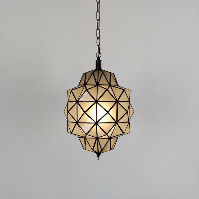 Handmade geometric hanging light with a spherical shape and detailed metal pattern.