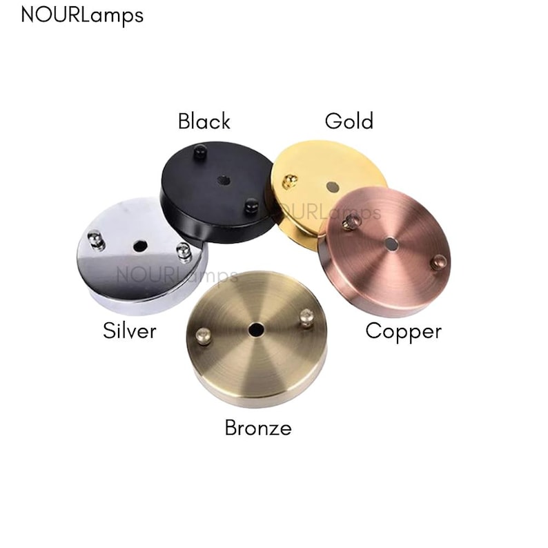 Op de afbeelding: Vijf ronde plafondbedekkingen voor armaturen in verschillende afwerkingen: zwart, goud, zilver, koper en brons.
