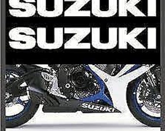 May include: A black and white motorcycle with the word "Suzuki" printed on the side. The motorcycle has a white and blue paint scheme.