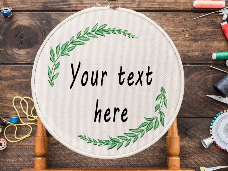 May include: A white embroidery hoop with a green leafy design and the text "Your text here".