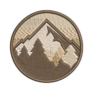 Puede incluir: Parche bordado circular que representa una cordillera y abetos en tonos marrón, beige y blanco. El diseño tiene un patrón de puntadas detallado, ideal para entusiastas del aire libre y amantes de la naturaleza.