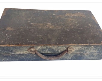 May include: A vintage wooden box with a metal handle. The box is dark brown and has a worn, distressed look.