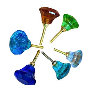 Può includere: Sei pomelli per armadi in vetro colorato con viti in metallo dorato. I pomelli hanno la forma di diamanti e sono disponibili in blu, turchese, verde, marrone e trasparente.