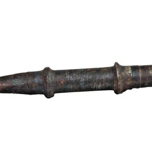 May include: A rusty metal spike with a pointed tip and a cylindrical body. The spike has a small hole at the end of the cylinder.