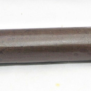 Può includere: Un tubo di metallo marrone con un'estremità leggermente arrotondata. Il tubo è lungo circa 25 cm e ha un diametro di circa 2,5 cm.