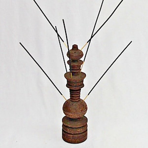 May include: A wooden incense holder with a tiered design and multiple slots for incense sticks. The holder is dark brown and has a natural wood finish.