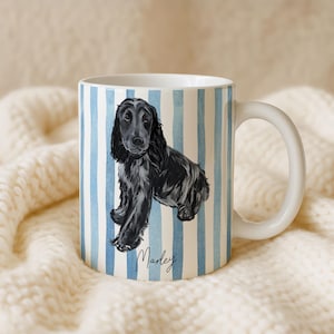 Puede incluir: Taza de cer&aacute;mica blanca con una ilustraci&oacute;n de acuarela de un perro negro con orejas largas. La taza tiene un patr&oacute;n de rayas azules y blancas y el nombre "Marley" en escritura cursiva. La taza tiene un asa blanca.