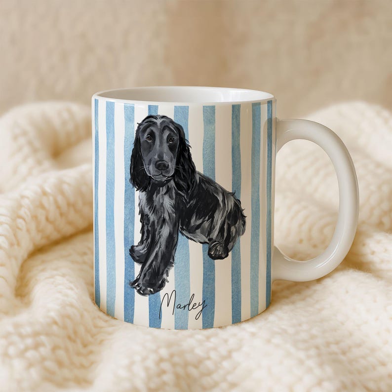 Puede incluir: Taza de cer&aacute;mica blanca con una ilustraci&oacute;n de acuarela de un perro negro con orejas largas. La taza tiene un patr&oacute;n de rayas azules y blancas y el nombre "Marley" en escritura cursiva. La taza tiene un asa blanca.
