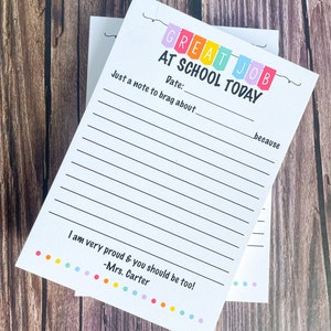 May include: White notepad with the text "GREAT JOB AT SCHOOL TODAY" in colorful letters. The notepad has lines for writing and includes the text "Just a note to brag about" and "I am very proud & you should be too! -Mrs. Carter".