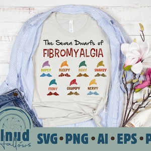 Pode incluir: Uma camiseta branca com o texto "The Seven Dwarfs of Fibromyalgia" e ilustrações de sete anões com nomes como "Dopey", "Sleepy", "Achy", "Shakey", "Itchy", "Grumpy" e "Nervy".