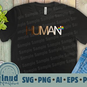 May include: Black t-shirt with the word "HUMAN" in brown letters and a rainbow-colored bow tie. The shirt is on a wooden background with a pair of blue jeans and a white shoe.