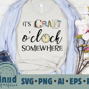 May include: A white t-shirt with the text "It's Craft o'clock Somewhere" in black lettering. The word "Craft" is made up of colorful letters with a floral design. A clock face is included in the design.