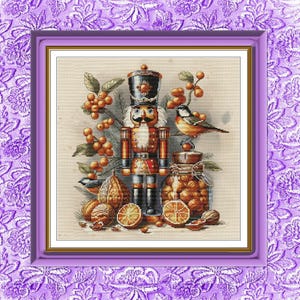 May include: A cross-stitch pattern featuring a central nutcracker figure in a black hat and red uniform, surrounded by orange berries, pine needles, a small bird, a glass jar filled with nuts, and sliced oranges on a light beige fabric background.
