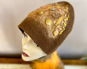 May include: A brown felt hat with a unique design featuring gold and silver embellishments. The hat has a rounded shape and a slightly slouched crown.