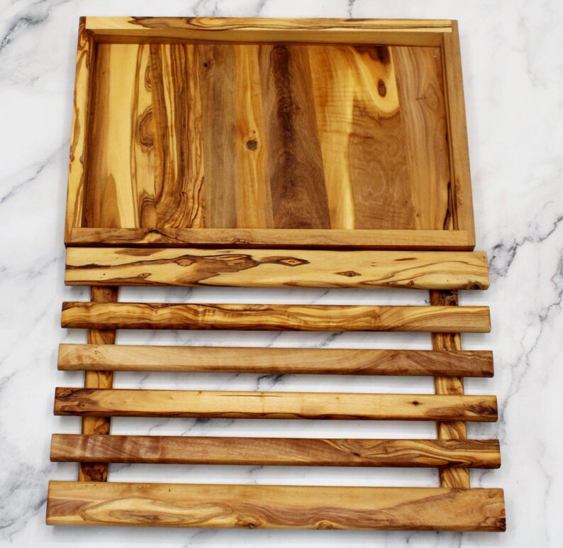 Puede incluir: Una bandeja de servir de madera con una base de listones. La bandeja est&aacute; hecha de madera de olivo y tiene un acabado natural. La bandeja es perfecta para servir aperitivos, entrantes o postres.